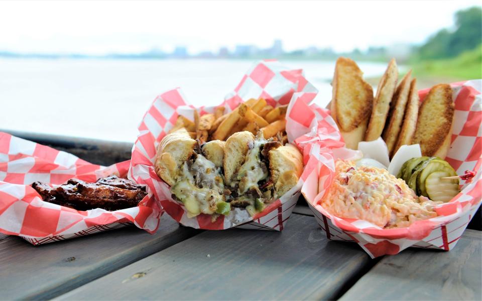 An order of wings with Caribbean BBQ sauce, a steak Philly sandwich with seasoned fries, and pimento cheese from the Old Fashioned Butcher Shoppe are served on the Dive Barge on Thursday, Aug. 3, 2023.