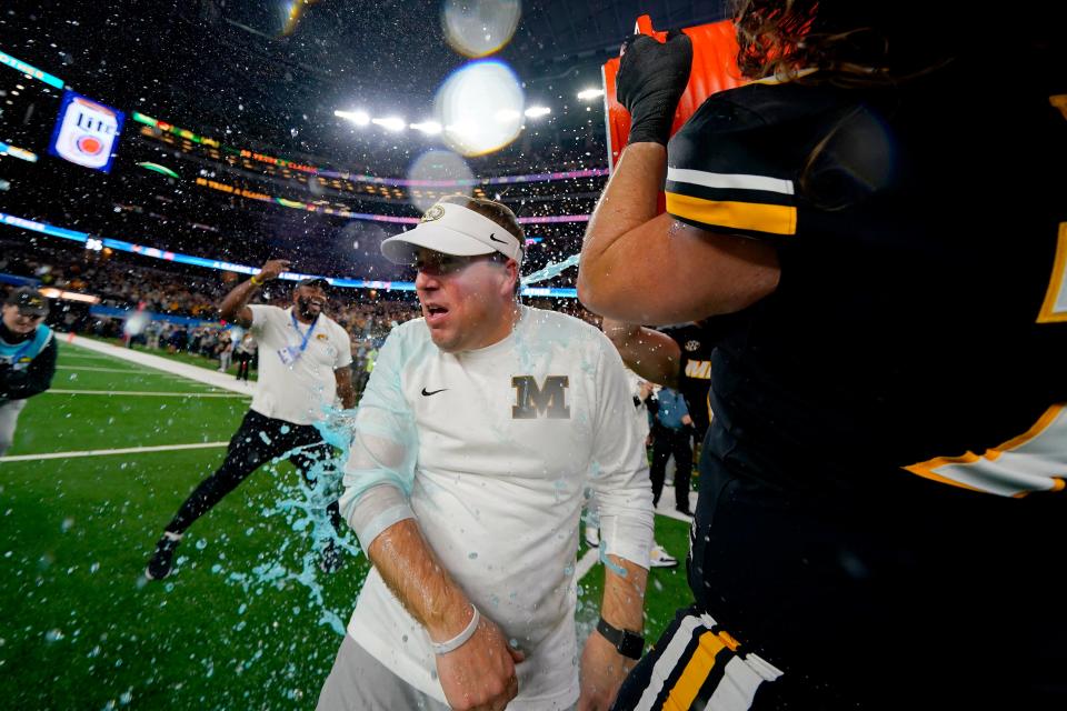 Missouri coach Eliah Drinkwitz celebrates with players and assistant coaches in the closing minutes of the team's Cotton Bowl NCAA college football game against Ohio State on Friday, Dec. 29, 2023, in Arlington, Texas. (AP Photo/Julio Cortez)