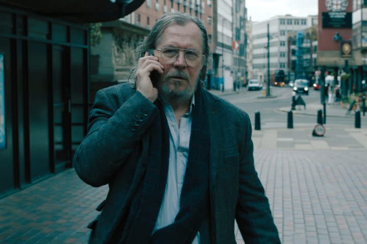 A man on a phone walks down the street.