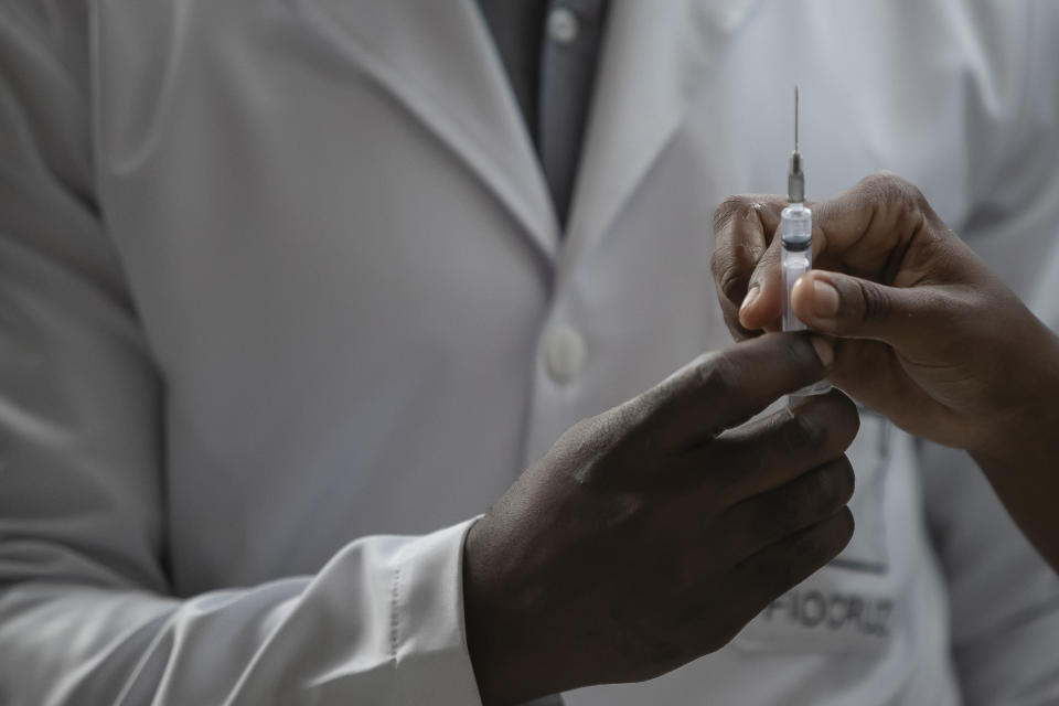 Healthcare workers prepare to inject a front-line healthcare worker with a dose of the Oxford-AstraZeneca vaccine for COVID-19, at the Oswaldo Cruz Foundation headquarters in Rio de Janeiro, Brazil, Saturday, Jan. 23, 2021. (AP Photo/Bruna Prado)