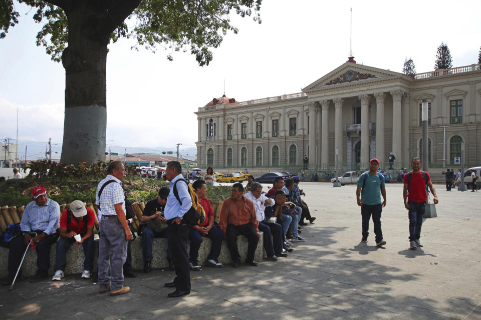 Salvadoran citizens rest in shade of the Gerardo Barrios Plaza before the arrival of California Gov. Gavin Newsom in San Salvador, El Salvador, Sunday, April 7, 2019. Newsom visited the tomb of Archbishop Romero, the Salvadoran priest assassinated in 1980 due to his advocacy for human rights and the poor. (AP Photo/Salvador Melendez)