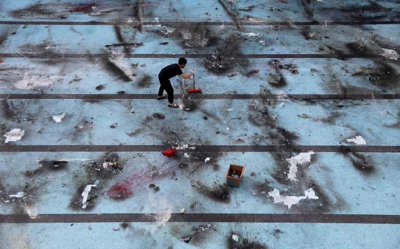 An anti-government protester cleans up after protests at the Polytechnic University in Hong Kong