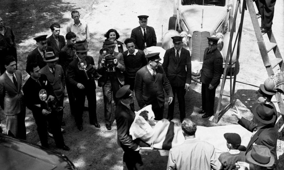 Photographers take pictures of an unidentified survivor of the disaster the previous day.