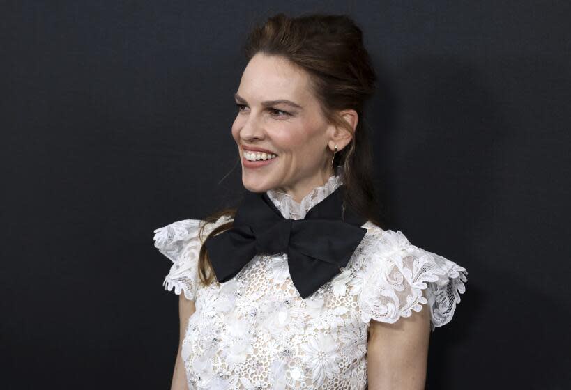 Hilary Swank smiles in white lace top and oversized black bow tie at LA Special Screening of "The Hunt"