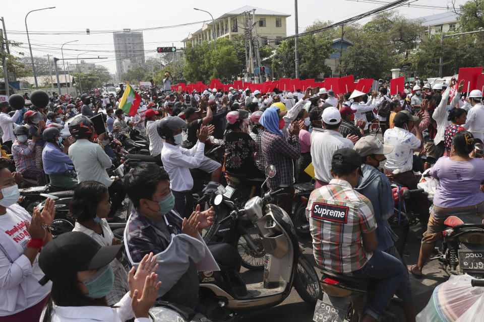 Motorist applaud while students march during a street march in Mandalay, Myanmar, Friday, Feb. 26, 2021. In the country’s second-largest city, anti-coup protesters took to the streets Friday. By midday, security forces had blocked the main road in downtown Mandalay to prevent the protesters from gathering. (AP Photo)