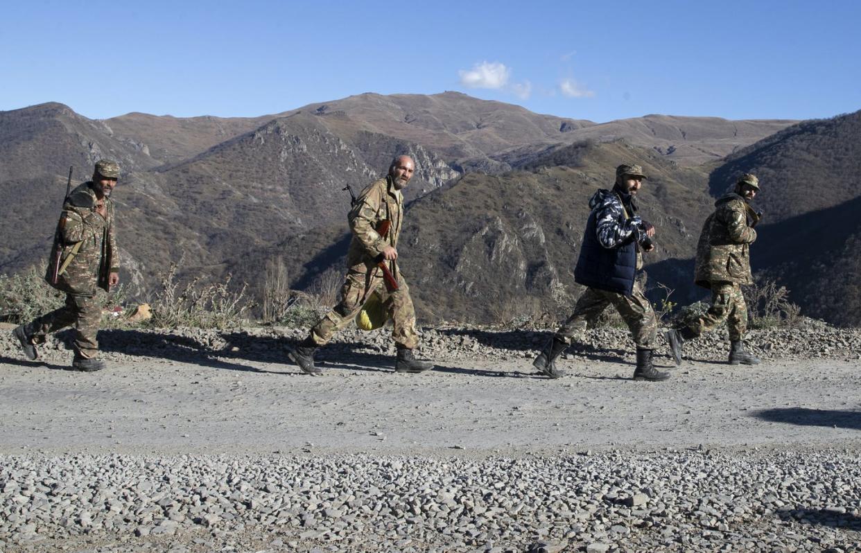 <span class="caption">Soldiers patrol the mountainous, disputed border between Armenia and Azerbaijan, Nagorno-Karabakh, on Nov. 8.</span> <span class="attribution"><a class="link " href="https://www.gettyimages.com/detail/news-photo/servicemen-walk-towards-the-armenian-border-the-fighting-news-photo/1229530009?adppopup=true" rel="nofollow noopener" target="_blank" data-ylk="slk:Stanislav Krasilnikov\TASS via Getty Images;elm:context_link;itc:0;sec:content-canvas">Stanislav Krasilnikov\TASS via Getty Images</a></span>