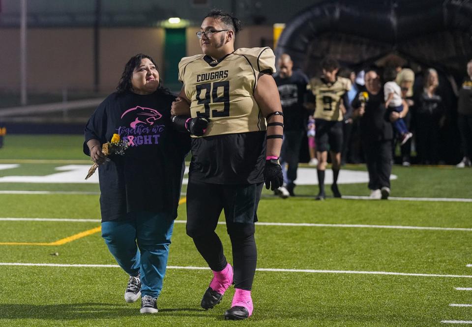 Amado Peña-Gonzalez walks with his mom, Adela Peña, as he is recognized during Crockett High School senior night before a game against Northeast at Burger Center. Amado calls his mother his inspiration.