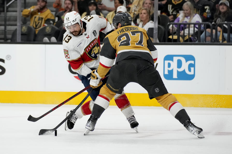 Vegas Golden Knights defenseman Shea Theodore defends against Florida Panthers center Sam Reinhart (13) during the third period of Game 1 of the NHL hockey Stanley Cup Finals, Saturday, June 3, 2023, in Las Vegas.  (AP Photo/John Locher)