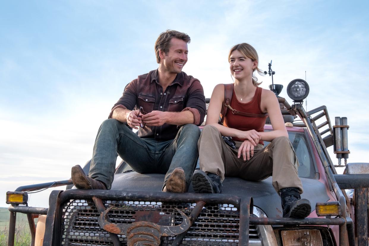 Glen Powell and Daisy Edgar-Jones sit on a vehicle in the film Twisters.