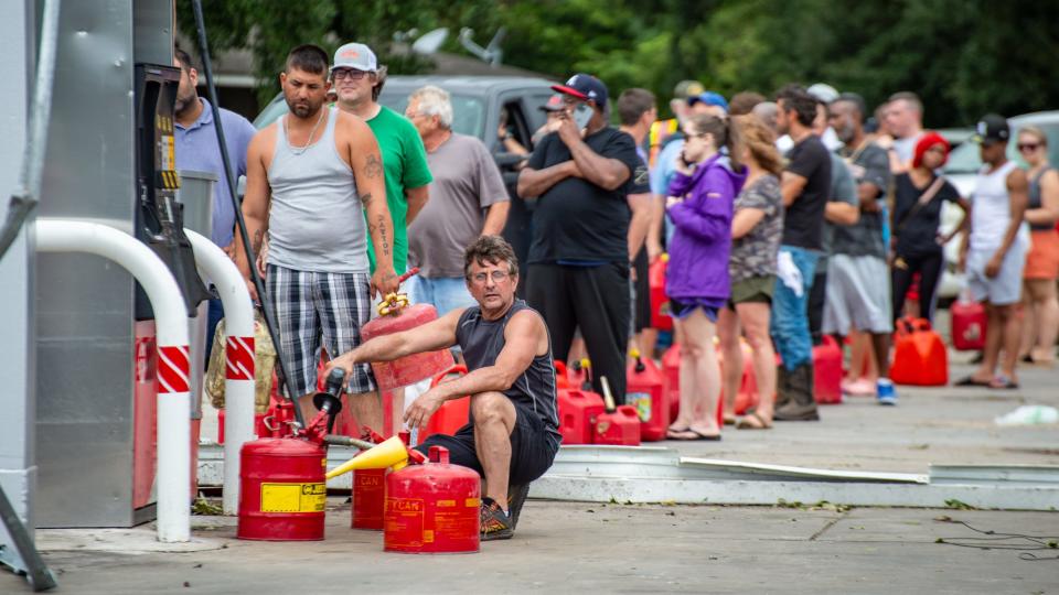 About 24 hours after Hurricane Ida made landfall in southeast Louisiana, lines of people waited Monday, Aug. 30, 2021 to fill cans with gas at a station and store called Veillon’s in Prairieville.