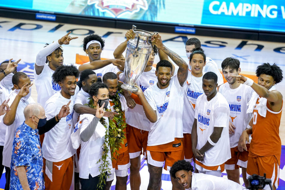 Texas celebrates with the trophy for the NCAA college basketball game championship of the Maui Invitational after they beat North Carolina 69-67, Wednesday, Dec. 2, 2020, in Asheville, N.C. (AP Photo/Kathy Kmonicek)