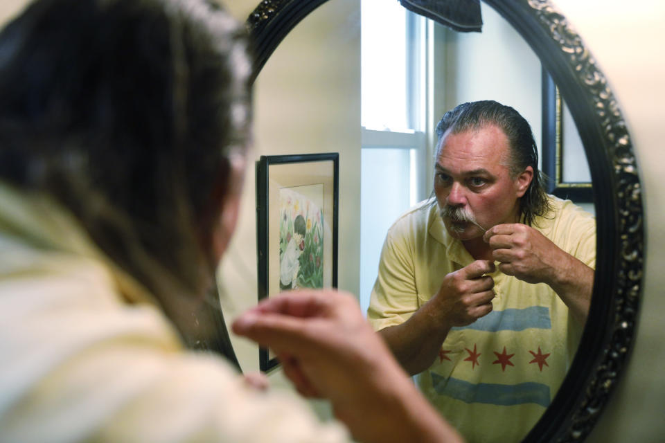 Dan O'Connor styles his mustache before exiting his house for his 365th plunge into Lake Michigan, Saturday, June 12, 2021, in Chicago's Lincoln Park. (AP Photo/Shafkat Anowar)
