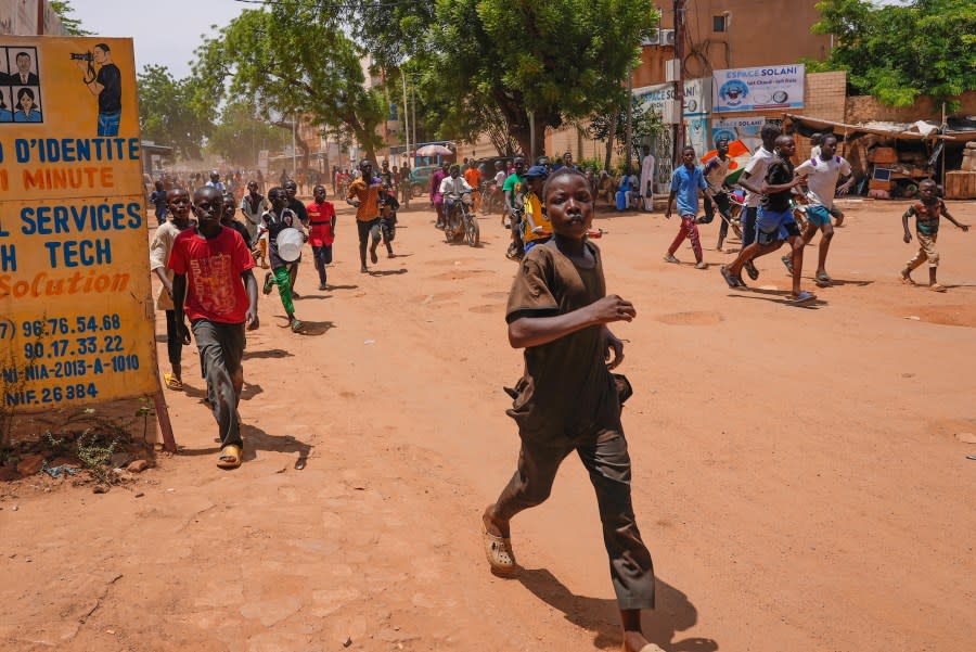 Children run in the streets of Niamey, Niger, Sunday, Aug. 13, 2023. People marched, biked and drove through downtown Niamey, chanting “down with France” and expressing anger at ECOWAS. (AP Photo/Sam Mednick)