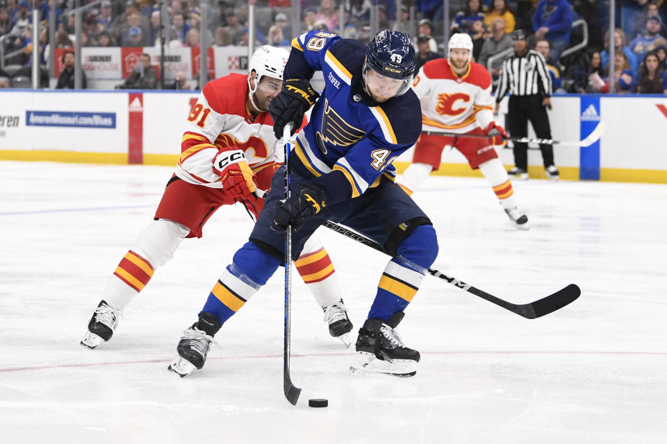 St. Louis Blues' Ivan Barbashev (49) controls the puck against Calgary Flames' Nazem Kadri (91) during the second period of an NHL hockey game Thursday, Jan. 12, 2023, in St. Louis. (AP Photo/Jeff Le)