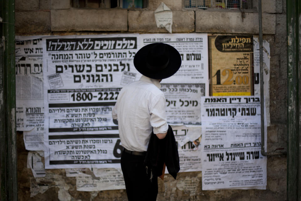 In this photo taken Tuesday, Sept. 27, 2011, an ultra-Orthodox Jewish man reads <em>pashkevilim</em>, posters used to publicize news and important messages in the ultra-Orthodox community, in Jerusalem's religious Mea Shearim neighborhood. An ultra-Orthodox collector has teamed up with Israel's National Library to bring this old-fashioned form of communication into the 21st century by scanning more than 20,000 of the posters into a digital online archive. The project offers a glimpse into one of the main media used by a group trying to hold the line against the march of modernity. (AP Photo/Bernat Armangue)