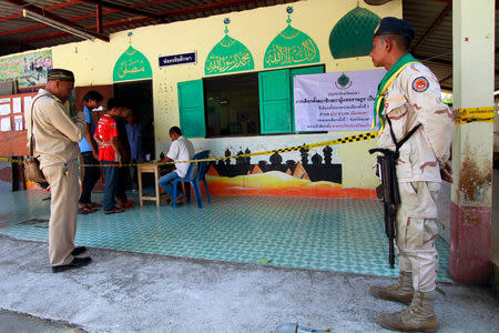 Military personnel stand guard as people arrive to vote in the general election at a polling station in Yala province, Thailand, March 24, 2019. REUTERS/Surapan Boonthanom