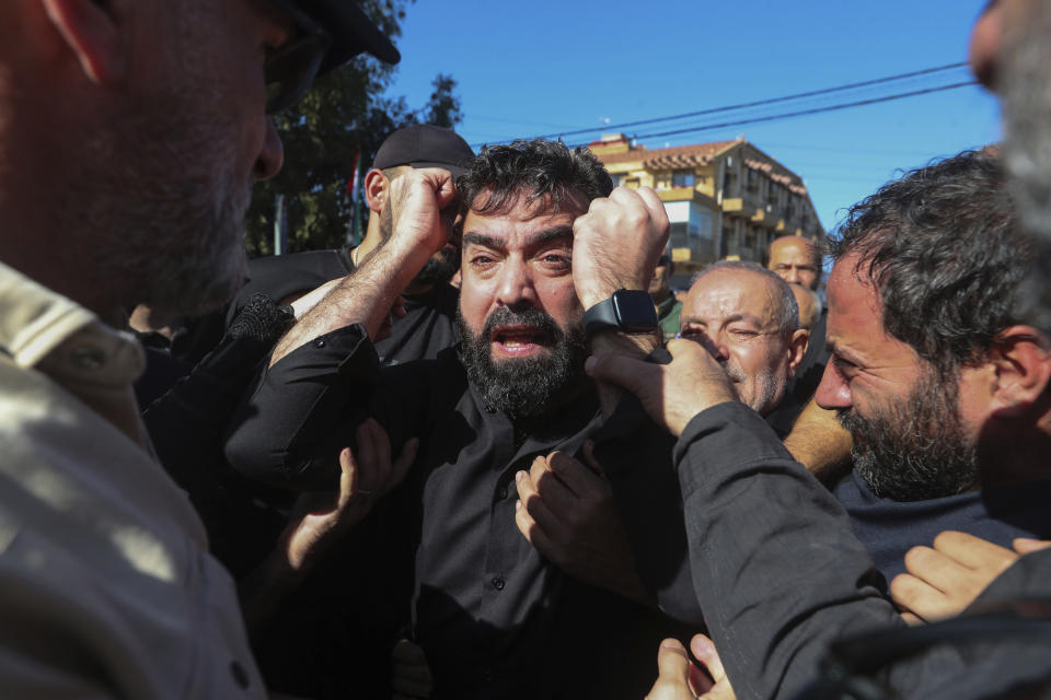 Mahmoud Shor, center, the father of the three children who were killed with their grandmother by an Israeli airstrike weeps during their funeral procession in the town of Ainata, a Lebanese border village with Israel in south Lebanon, Tuesday, Nov. 7, 2023. A Lebanese woman and her three grand daughters were laid to rest in their hometown in southern Lebanon two days after they were killed in an Israeli drone strike while in a car near the Lebanon-Israel border. (AP Photo/Mohammed Zaatari)