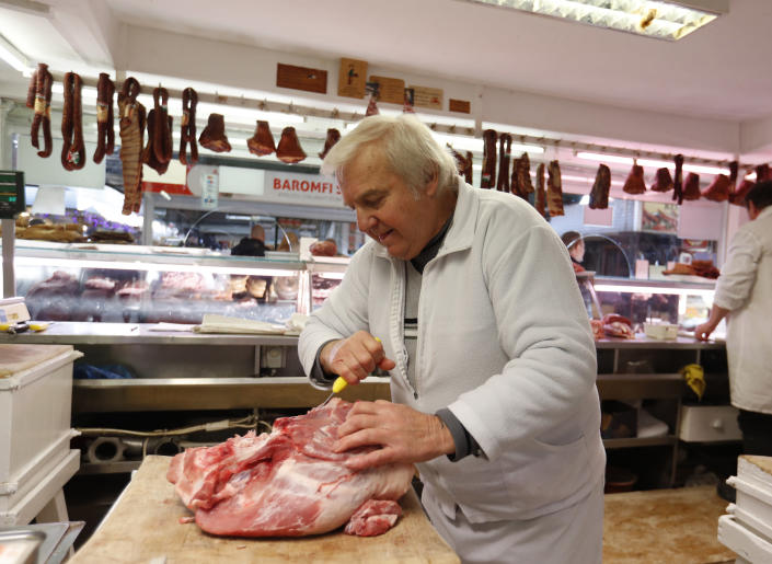 Vendor Misi Kovacs prepers the meat to sell, in a food market in Budapest, Hungary, Nov. 20, 2021. From appliance stores in the United States to food markets in Hungary and gas stations in Poland, rising consumer prices fueled by high energy costs and supply chain disruptions are putting a pinch on households and businesses worldwide. As economies recover from lockdowns caused by the COVID-19 pandemic, increased consumer demand has helped lead to rising inflation. (AP Photo/Laszlo Balogh