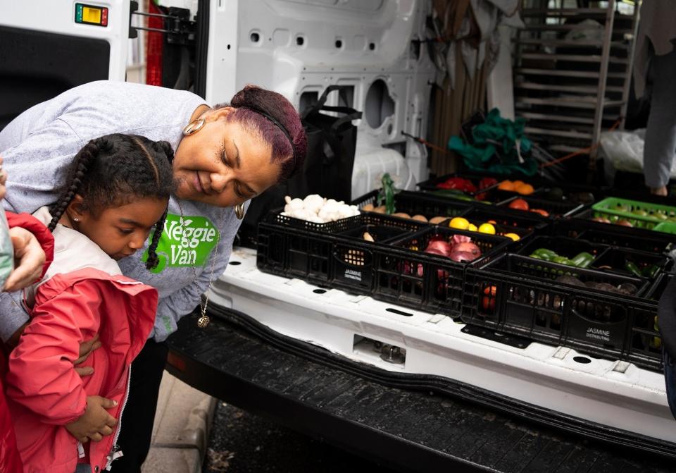 Monique McCoy, Veggie Van manager, greets Aiyana Barnes, 6, before helping her pick out fresh produce for her family on the Hilltop earlier this year during the Veggie Van, an initiative of Local Matters, a mobile grocer and food-education program on wheels.