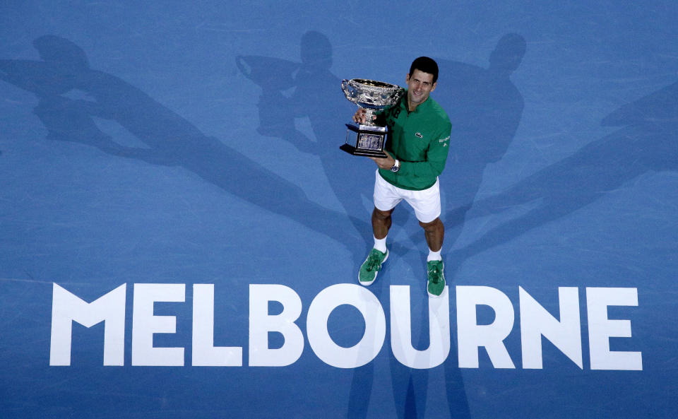 FILE - In this Feb. 3, 2020, file photo, Serbia's Novak Djokovic holds the Norman Brookes Challenge Cup after defeating Austria's Dominic Thiem in the men's singles final of the Australian Open tennis championship in Melbourne, Australia. The political leader of Australia's Victorian state says Wednesday, Nov. 18, 2020, despite "incredibly complex" negotiations, he is confident January's Australian Open tennis tournament will proceed. (AP Photo/Andy Wong)