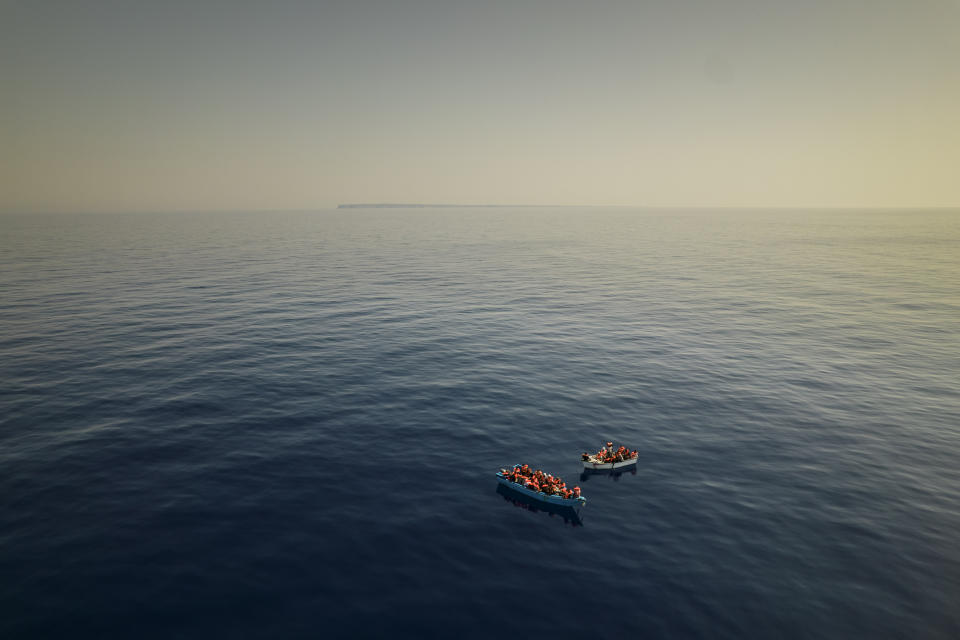 FILE - In this Thursday July 29, 2021 file photo, a group thought to be migrants from Tunisia aboard precarious wooden boats wait to be assisted by a team of the Spanish NGO Open Arms, around 20 miles southwest from the Italian island of Lampedusa, in Italian SAR zone. The NGO assisted more than 170 people who arrived next to the Italian island on board six different wooden dinghies, before the Italian authorities took them to land. (AP Photo/Santi Palacios, File)