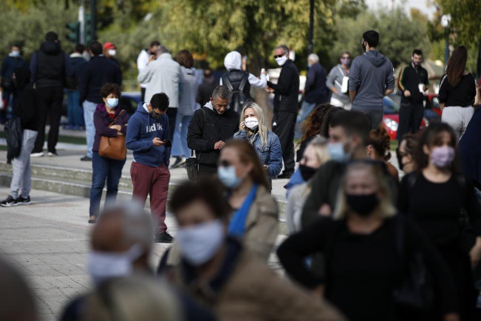 People stand in a queue as they wait to for rapid COVID 19 tests by the National Health Organization (EODY) in Athens, Thursday, Nov. 5, 2020. Greek Prime Minister Kyriakos Mitsotakis has announced a nationwide three-week lockdown starting Saturday morning, saying that the increase in the coronavirus infections must be stopped before Greece's health care system comes under "unbearable" pressure. (AP Photo/Thanassis Stavrakis)