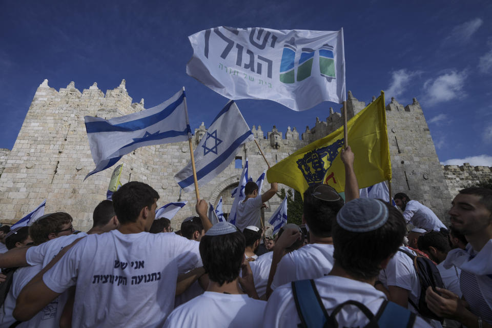 Israelis wave national flags during a march marking Jerusalem Day, an Israeli holiday celebrating the capture of east Jerusalem in the 1967 Mideast war, in front of the Damascus Gate of Jerusalem's Old City, Thursday, May 18, 2023. (AP Photo/Mahmoud Illean)