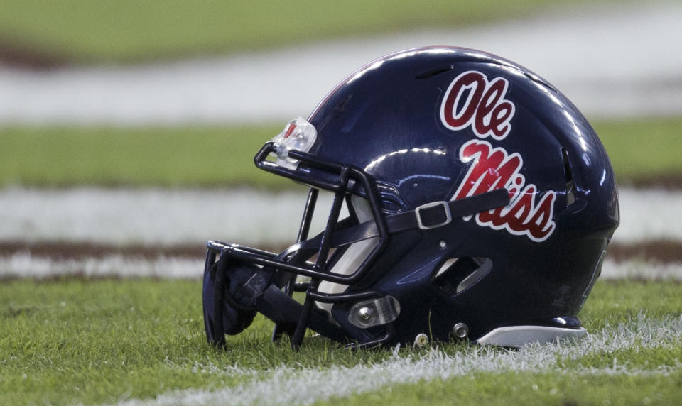 An Ole Miss helmet sits alone on the field. 