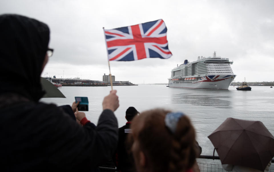 <p>A person waves a Union flag as the new P&O cruise ship Iona enters Southampton for the first time ahead of its naming ceremony. Iona, the largest cruise ship built for the UK market, is 345 metres long (1,132ft), weighs 185,000 tonnes, and has 17 passenger decks, creating capacity for 5,200 holidaymakers. Picture date: Sunday May 16, 2021.</p>
