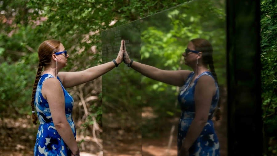 GVSU alum Samantha Butcher holds her hand to the memorial wall on Grand Valley State University's campus on May 24, 2024. (Courtesy Kendra Stanley-Mills/GVSU)