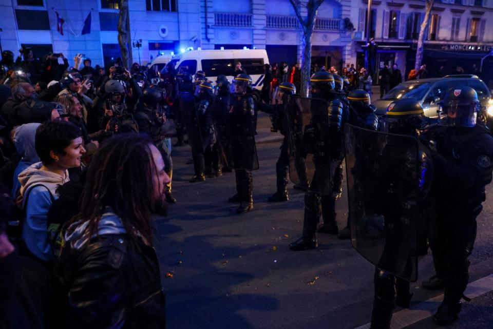 Riot police officers face demonstrators in Paris on Monday, March 20  (REUTERS)