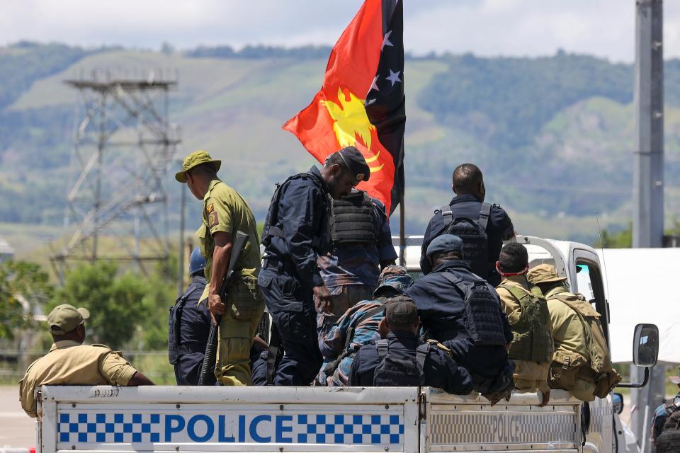 Papua New Guinea police arrive at the airport in Honiara, Solomon Islands, Saturday, Nov. 27, 2021. Solomon Islands police have found multiple bodies in a burned-out building and arrested more than 100 people in this week's violence sparked by concerns about the Pacific nation's increasing links with China.