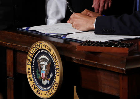 U.S. President Barack Obama signs the Affordable Care Act, dubbed Obamacare, the comprehensive healthcare reform legislation during a ceremony in the East Room of the White House in Washington, U.S., March 23, 2010. REUTERS/Jim Young/File Photo