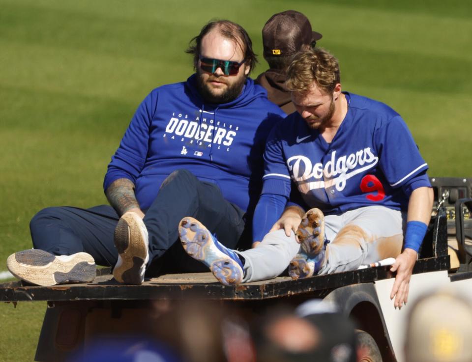 Gavin Lux leaves the field on the back of a golf cart after injuring his right knee Monday in Peoria, Ariz.