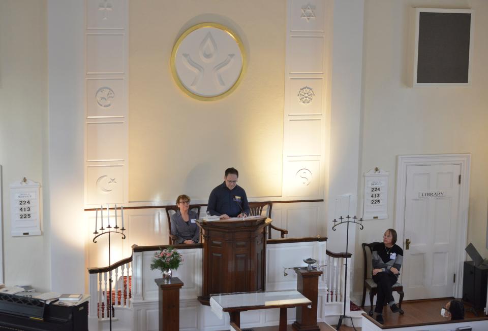 Joe Lima, president of PFLAG of Cape Cod, center, speaks during Sunday's vigil, held at the Unitarian Church of Barnstable to remember the victims of the Nov. 19 mass shooting at Club Q, a gay nightclub in Colorado Springs.