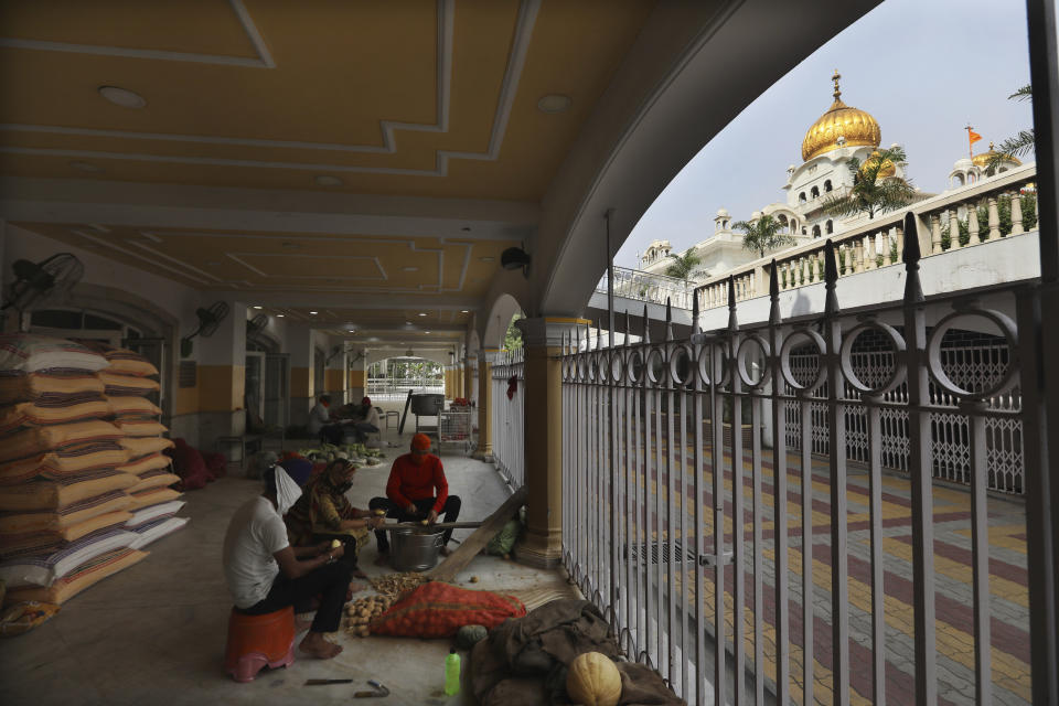 Sikh volunteers chop vegetables outside their kitchen hall at the Bangla Sahib Gurdwara in New Delhi, India, Sunday, May 10, 2020. The Bangla Sahib Gurdwara has remained open through wars and plagues, serving thousands of people simple vegetarian food. During India's ongoing coronavirus lockdown about four dozen men have kept the temple's kitchen open, cooking up to 100,000 meals a day that the New Delhi government distributes at shelters and drop-off points throughout the city. (AP Photo/Manish Swarup)