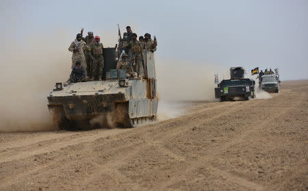 Shi'ite fighters ride on military vehicles heading toward the airport of Tal Afar during a battle with Islamic State militants in Tal Afar west of Mosul, Iraq, November 16, 2016. REUTERS/Stringer