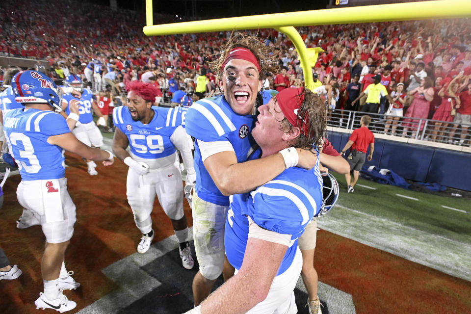 Mississippi quarterback Jaxson Dart, center, celebrates with offensive lineman Caleb Warren, right, after winning an NCAA college football game against LSU in Oxford, Miss., Saturday, Sept. 30, 2023. (AP Photo/Thomas Graning)