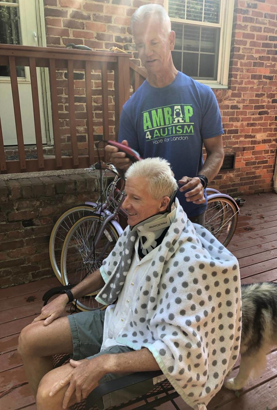 John Diggs gets a haircut on his back deck Wednesday from friend Bobby Buening.