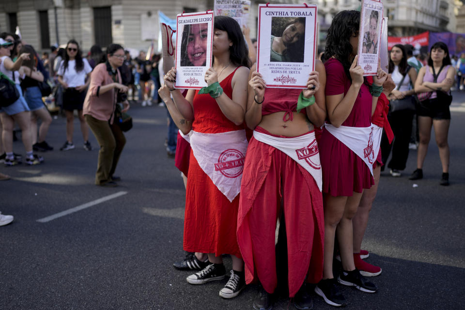 Manifestantes sostienen fotografías de víctimas de trata de personas durante una manifestación que conmemora el Día Internacional de la Eliminación de la Violencia contra la Mujer, en Buenos Aires, Argentina, el sábado 25 de noviembre de 2023. (Foto AP/Natacha Pisarenko)