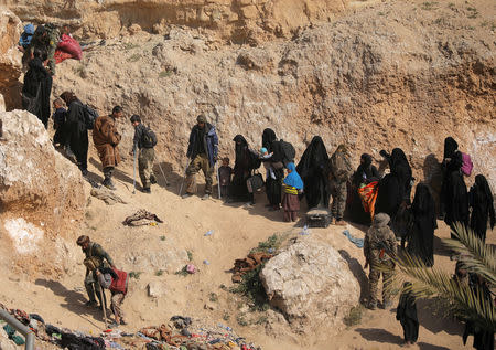 Islamic state fighters and their families walk as they surrendered in the village of Baghouz, Deir Al Zor province, Syria March 12, 2019. REUTERS/Rodi Said