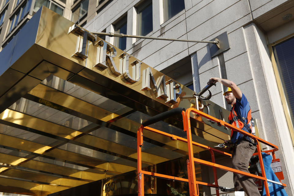FILE - In this Wednesday, Nov. 16, 2016 file photo, a worker removes letters from the awning of a building formerly known as Trump Place in New York. Donald Trump's name is being stripped off three luxury apartment buildings after hundreds of tenants signed a petition saying they were embarrassed to live in a place associated with the Republican president-elect. (AP Photo/Seth Wenig, File)