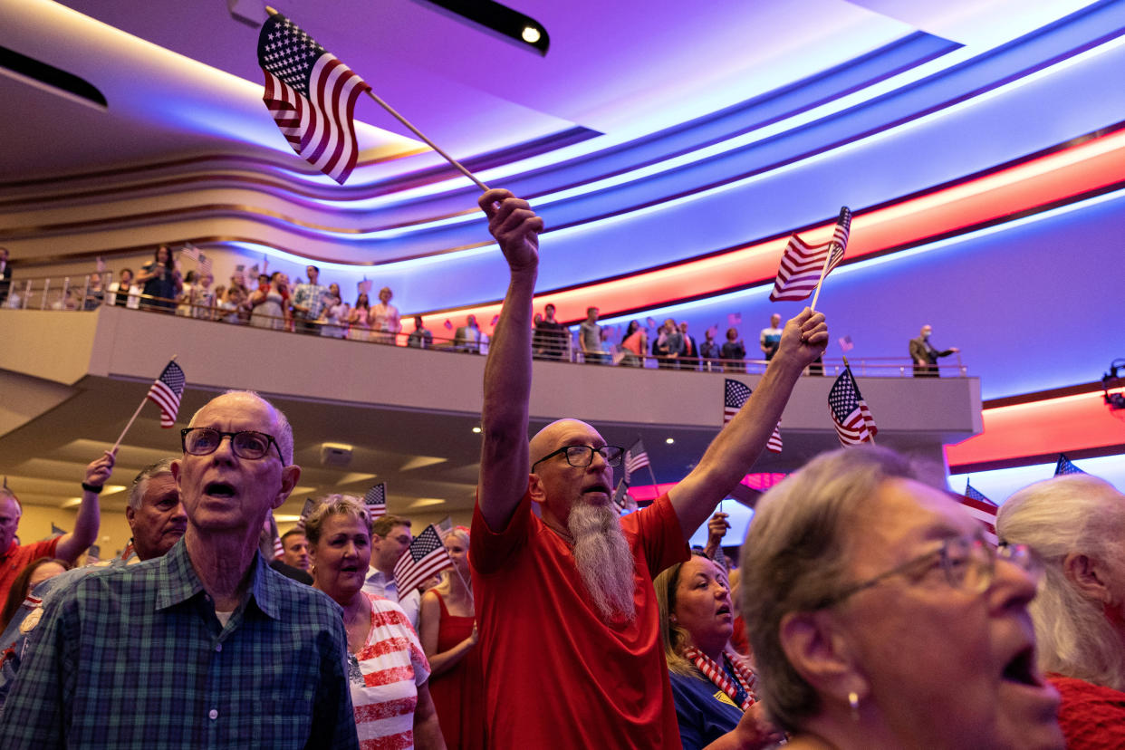 Dozens of congregants at the First Baptist evangelical Southern Baptist megachurch in Dallas stand, waving small American flags.