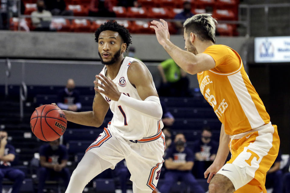 Auburn guard Jamal Johnson (1) brings the ball down court as Tennessee guard Santiago Vescovi (25) defends during the first half of an NCAA basketball game Saturday, Feb. 27, 2021, in Auburn, Ala. (AP Photo/Butch Dill)