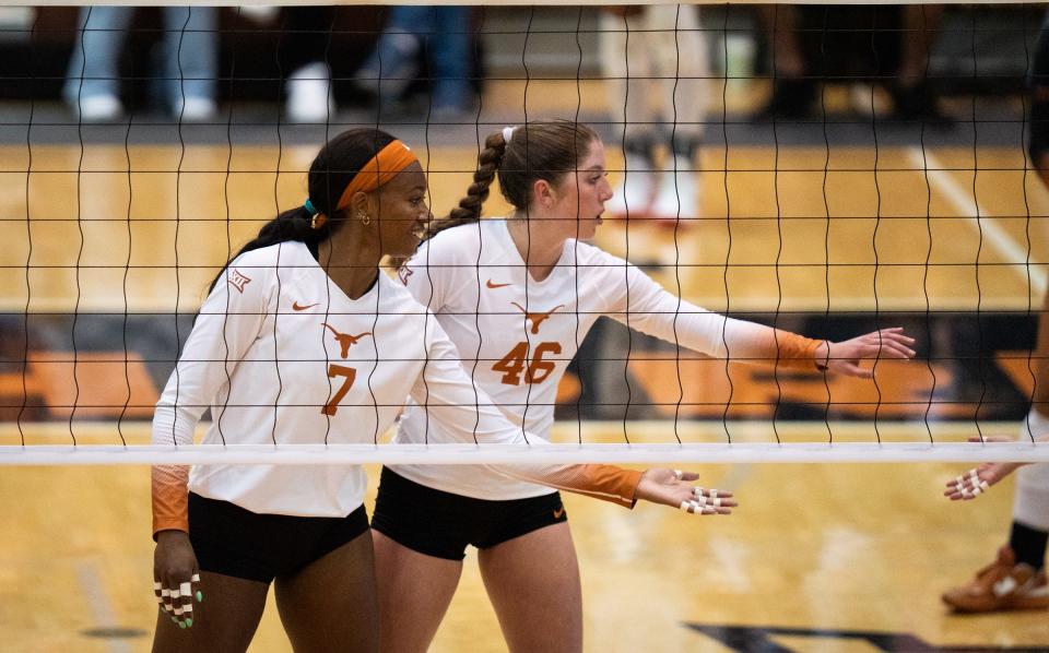 Texas middle blocker Asjia O'Neal, left, and setter Ella Swindle reach to slap five with a teammate during the Longhorns' match against Baylor. Swindle, a heralded freshman from Missouri, started alongside O'Neal and other veterans from last season's national championship team.