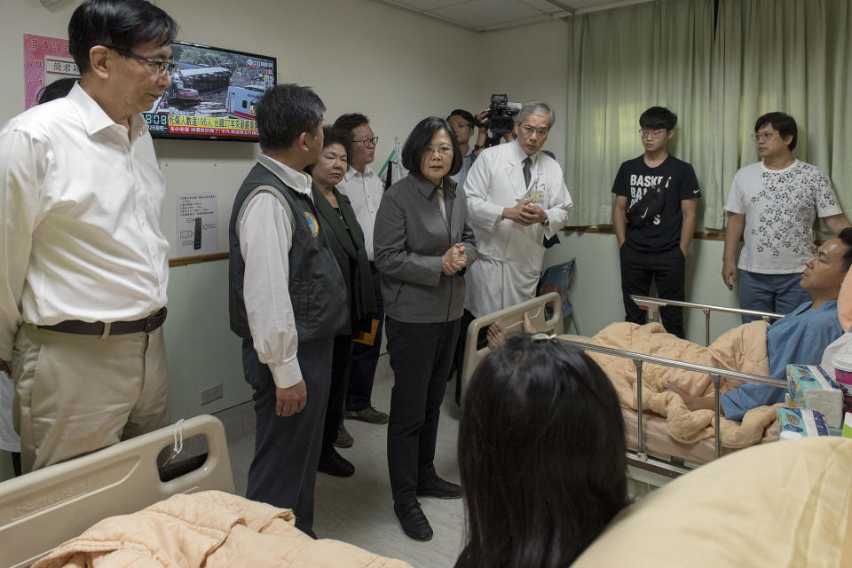 In this photo released by the Taiwan Presidential Office, Taiwanese President Tsai Ing-wen, center, visits victims from a train derailment at a hospital in Yilan county in northeastern Taiwan on Monday, Oct. 22, 2018. Passengers were killed and injured on Sunday when one of Taiwan's newer, faster trains derailed on a curve along a popular weekend route, officials said. (Taiwan Presidential Office via AP)