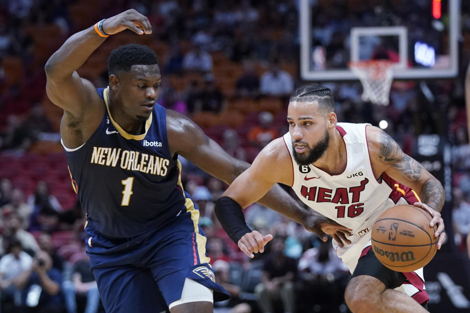 Miami Heat forward Caleb Martin (16) drives past New Orleans Pelicans forward Zion Williamson (1) during the first half of a preseason NBA basketball game, Wednesday, Oct. 12, 2022, in Miami. (AP Photo/Wilfredo Lee)