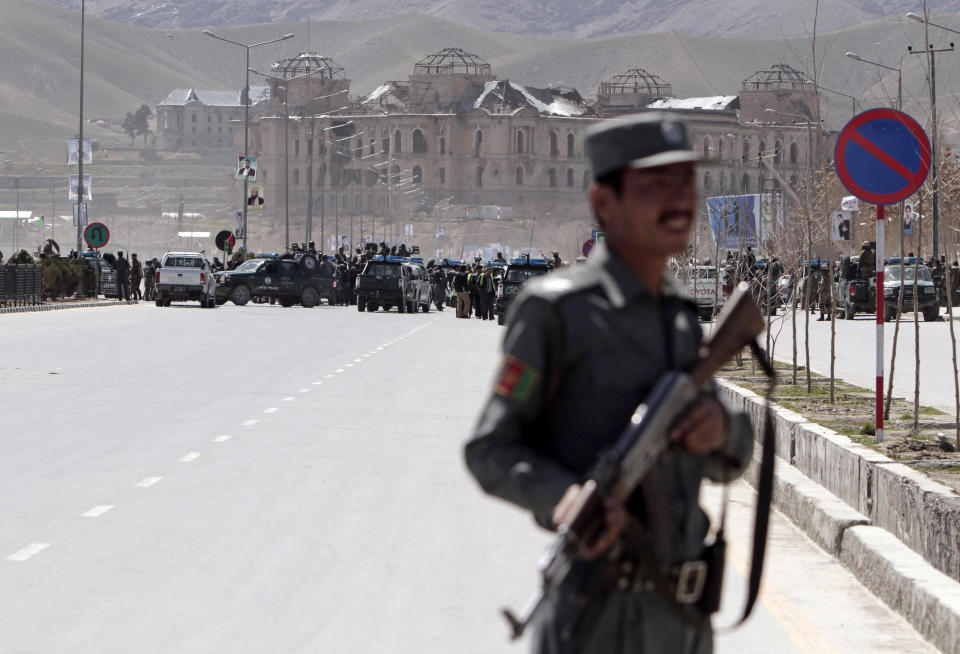 Afghan security officers arrive to the scene after two suicide bombers have struck near the home of candidate running for president, Ashraf Ghani Ahmadzai in the country's April 5 elections, in Kabul, Afghanistan, Tuesday, March 25, 2014. An Afghan police official said two suicide bombers were dead but another four insurgents may still be inside the election commission office. Witnesses reported heavy gunfire and scores of heavily armed troops with Afghanistan’s rapid response force had surrounded the building, located near the home of Ahmadzai. (AP Photo/Rahmat Gul)