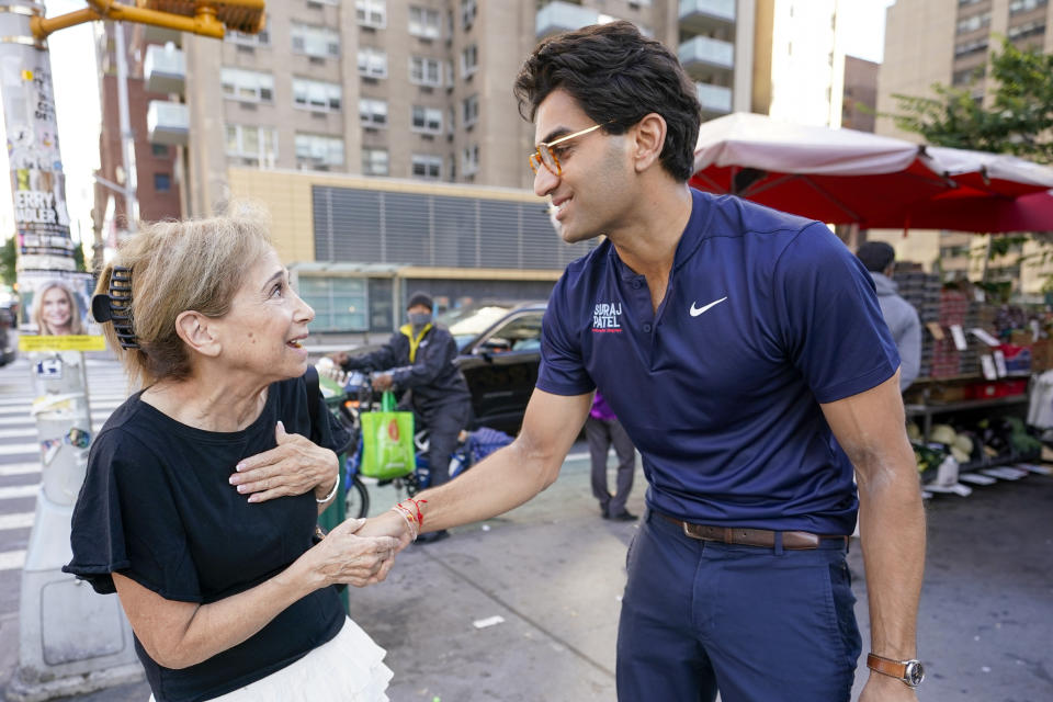 Suraj Patel shakes hands with an excited-looking voter.