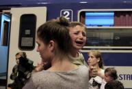 A child cries in frustration as his parents try to honour ticket control rules which now mandate each passenger to have allocated seats on trains bound for the West from Budapest, Hungary, on August 31, 2015. REUTERS/Bernadett Szabo .